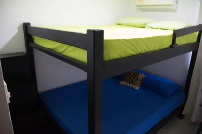 a bunk bed with blue and green sheets on it at Apartamento en Caribe campestre Coveñas in Coveñitas