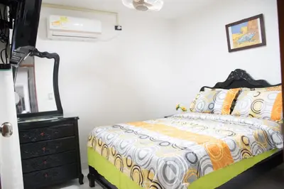 a bedroom with a bed and a dresser and a mirror at Apartamento en Caribe campestre Coveñas in Coveñitas
