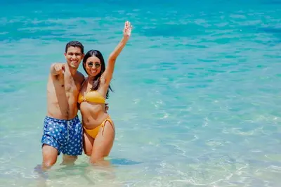 a man and a woman standing in the water at Solarium Beach Club in Playa Blanca