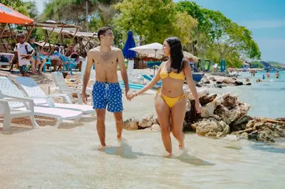 a man and a woman walking on the beach at Solarium Beach Club in Playa Blanca