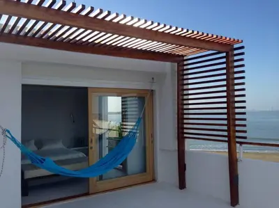 a hammock in a room with a view of the ocean at dhozt Marlinda Beach House. Cartagena Colombia in Cartagena de Indias