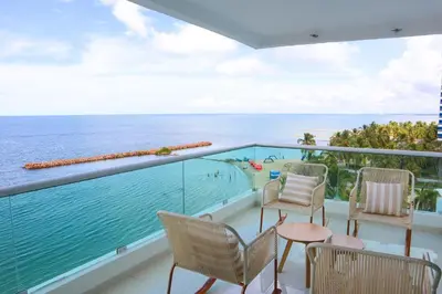 a balcony with chairs and a view of the ocean at Magico Apartamento Frente al Mar 4 Habitaciones O62 in Coveñas