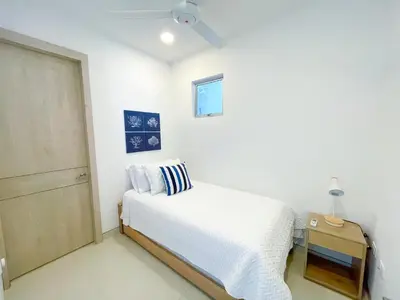 a white bedroom with a bed and a door at Magico Apartamento Frente al Mar 4 Habitaciones O62 in Coveñas