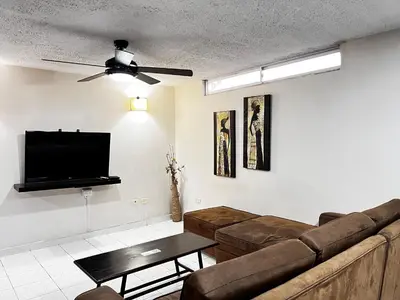 a living room with a couch and a flat screen tv at Hotel Boston Superior in Barranquilla