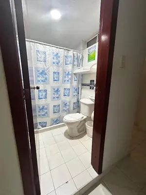 a bathroom with a toilet and blue and white tiles at Hotel Boston Superior in Barranquilla