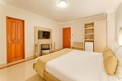 a bedroom with a large bed and a desk at Hotel Caribe 79 in Barranquilla
