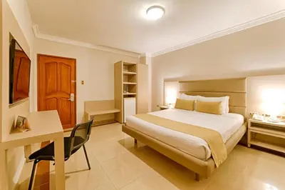 a hotel room with a bed and a desk and a desk at Hotel Caribe 79 in Barranquilla