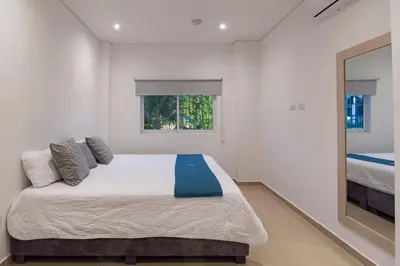 a bedroom with a large bed and a window at Amazing Beach House 13BR w/Pool & Staff in Cartagena de Indias