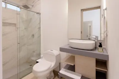a bathroom with a toilet and a sink and a shower at Amazing Beach House 13BR w/Pool & Staff in Cartagena de Indias