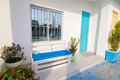 a balcony with a blue bench next to a window at Casa Playa James in La Boquilla