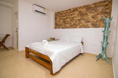 a bedroom with a bed with white sheets at Casa Playa James in La Boquilla