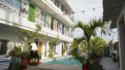 an apartment building with a swimming pool and an eagle statue at Casa Playa James in La Boquilla