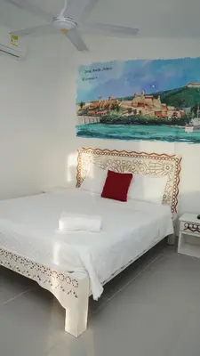 a bedroom with a bed with a painting on the wall at Casa Playa James in La Boquilla