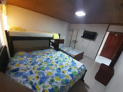 a bedroom with two bunk beds and a tv at Hotel Colonial Inn in Barranquilla
