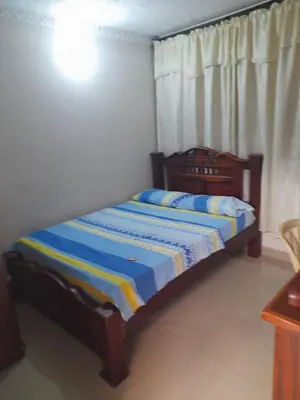 a bedroom with a bed with a blue and yellow striped sheets at Hotel Colonial Inn in Barranquilla