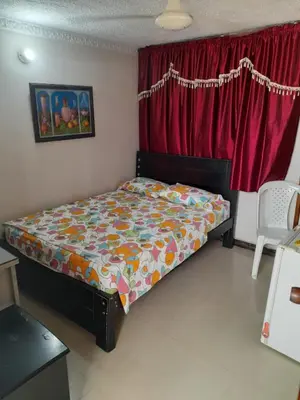 a bedroom with a bed in front of a red curtain at Hotel Colonial Inn in Barranquilla