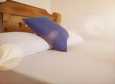 a blue pillow sitting on top of a bed at Tintipan Hotel in Tintipan Island