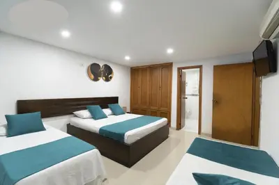a bedroom with two beds and a flat screen tv at AL-1C APARTAMENTO DE 1 ALCOBA CERCA AL MAR AIRE ACONDICIONADO WIFi Y PISCINA in Cartagena de Indias