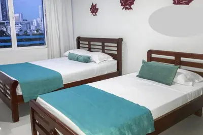 two twin beds in a room with a window at AL-1C APARTAMENTO DE 1 ALCOBA CERCA AL MAR AIRE ACONDICIONADO WIFi Y PISCINA in Cartagena de Indias