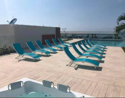 a row of lounge chairs next to a swimming pool at Apartamento en edificio con espectacular terraza in Cartagena de Indias