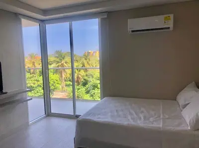a bedroom with a bed and a large window at Apartamento en edificio con espectacular terraza in Cartagena de Indias