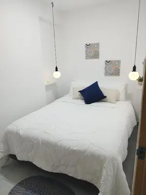 a bedroom with a white bed with a blue pillow at Apartamento moderno frente al mar in Cartagena de Indias