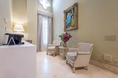 a living room with two chairs and a tv at Hotel Casa del Gobernador in Cartagena de Indias