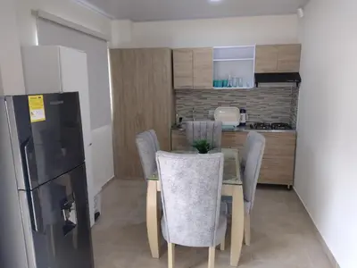 a kitchen with a table and chairs and a refrigerator at Cabañas OnBeach in San Antero