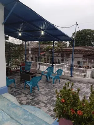 a patio with blue chairs under a blue canopy at Casa Santorini in Cartagena de Indias