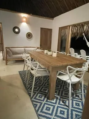 a dining room with a wooden table and white chairs at Casita del Viento in San Bernardo del Viento