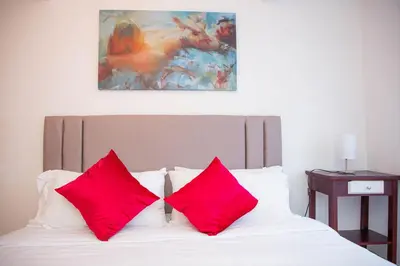 two red pillows sitting on top of a bed at CASA PETRA in Cartagena de Indias