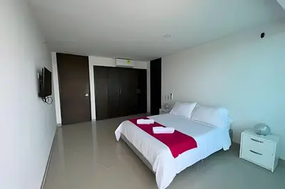 a bedroom with a large bed with a red blanket at 2 Dormitorios Morros. Vista Ciénaga y salida playa in Cartagena de Indias