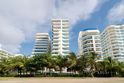 three tall white buildings with palm trees in the foreground at 2 Dormitorios Morros. Vista Ciénaga y salida playa in Cartagena de Indias