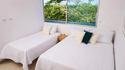 two beds in a room with two windows at Magico Apartamento Frente al Mar 4 Habitaciones PAZ335 in Coveñas