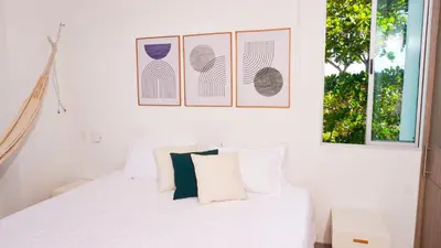a bedroom with a white bed with three pictures on the wall at Magico Apartamento Frente al Mar 4 Habitaciones PAZ335 in Coveñas