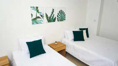 two beds in a room with green and white pillows at Magico Apartamento Frente al Mar 4 Habitaciones PAZ335 in Coveñas