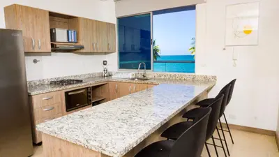 a kitchen with a large counter with a view of the ocean at Magico Apartamento Frente al Mar 4 Habitaciones PAZ335 in Coveñas