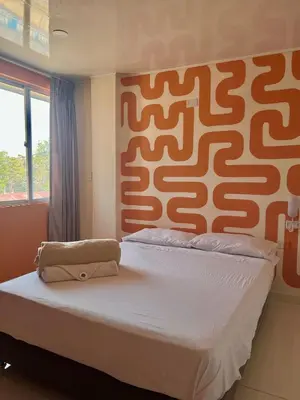 a bedroom with a large bed with a patterned headboard at Hotel Paranawa in Baranoa
