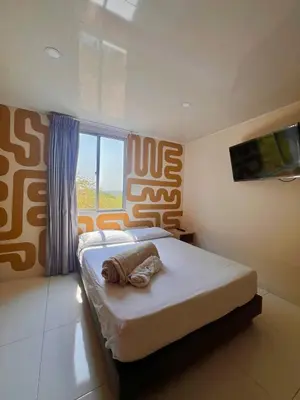 a bedroom with a bed with a towel on it at Hotel Paranawa in Baranoa