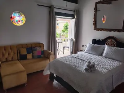 a bedroom with a bed and a couch and a window at EMMA HOTEL SAN DIEGO in Cartagena de Indias