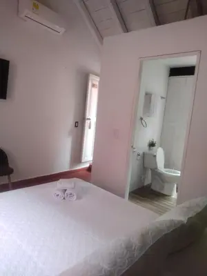 a white bedroom with a bed and a toilet at EMMA HOTEL SAN DIEGO in Cartagena de Indias