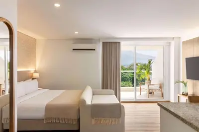 a hotel room with a bed and a balcony at Wyndham Residences Santa Marta Aluna Beach Club in Santa Marta