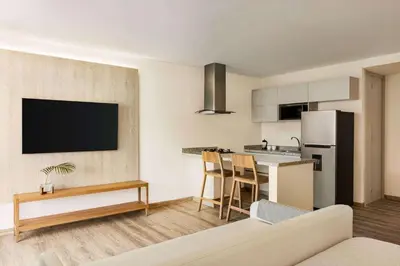 a living room with a couch and a kitchen at Wyndham Residences Santa Marta Aluna Beach Club in Santa Marta
