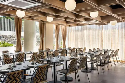 a row of tables and chairs in a room with windows at Wyndham Residences Santa Marta Aluna Beach Club in Santa Marta