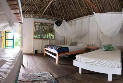 a room with two beds and a hammock in it at Cabañas La Múcura in San Onofre