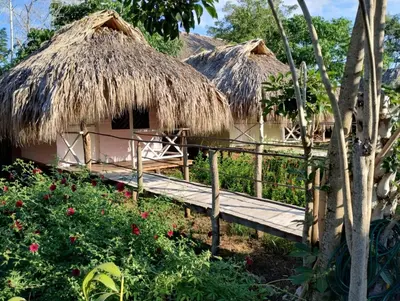 two huts with a bridge in front of them at Cabañas La Múcura in San Onofre