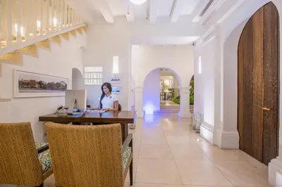 a woman sitting at a table with a computer in a room at Casa La Cartujita in Cartagena de Indias