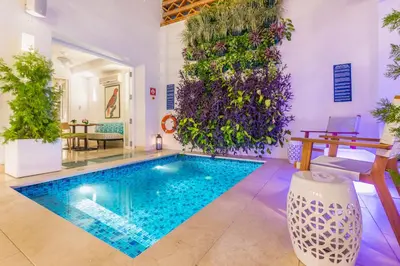 a swimming pool in a room with plants on the wall at Casa La Cartujita in Cartagena de Indias