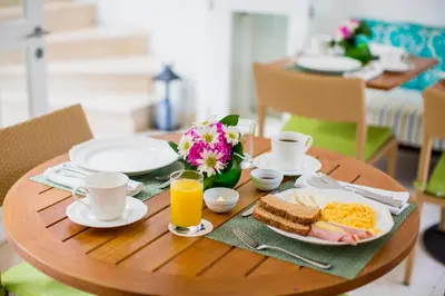 a wooden table with breakfast foods and orange juice at Casa La Cartujita in Cartagena de Indias