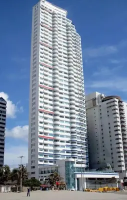 a tall white building in front of some buildings at Apto en Cartagena de Indias in Cartagena de Indias